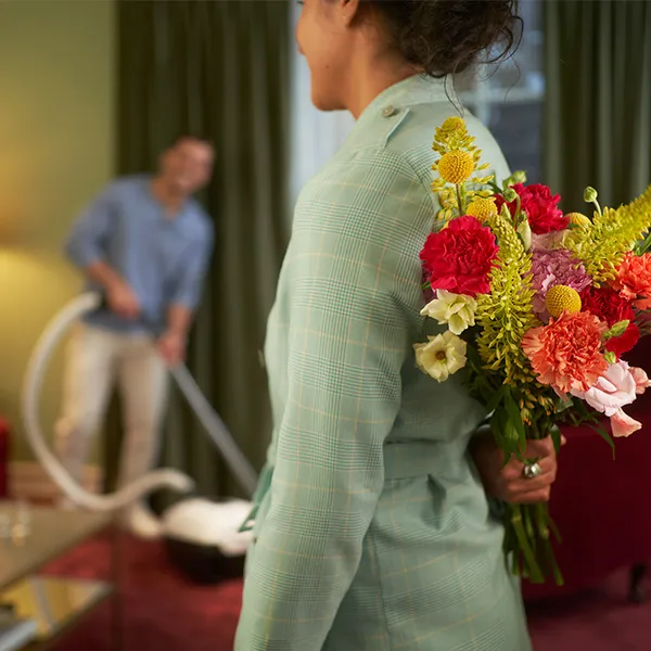 woman holding flowers behind her back